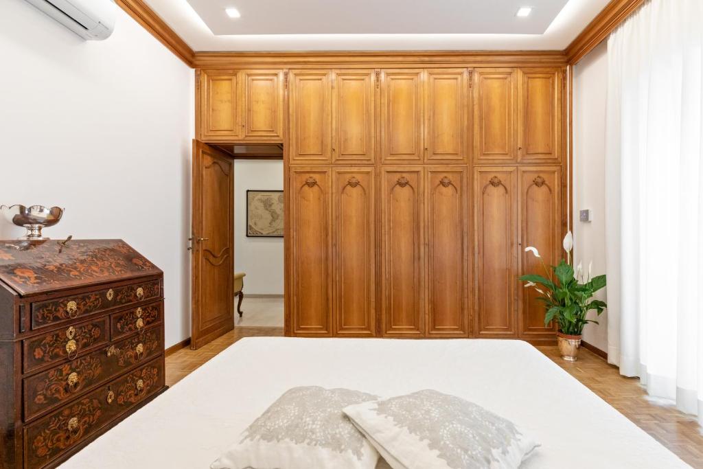 a bedroom with a wooden wardrobe and a bed at First Class Rome Apartments in Rome