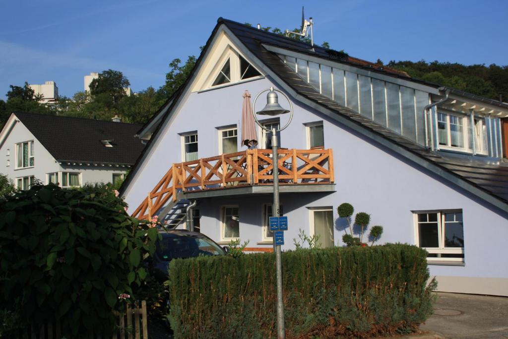 a white house with a wooden balcony on it at Ferienwohnung ANNA - charmante Ferienwohnung in bevorzugter Lage in Konstanz