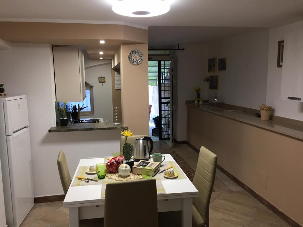una cucina e una sala da pranzo con tavolo e sedie bianchi di Loft Tropea a Tropea