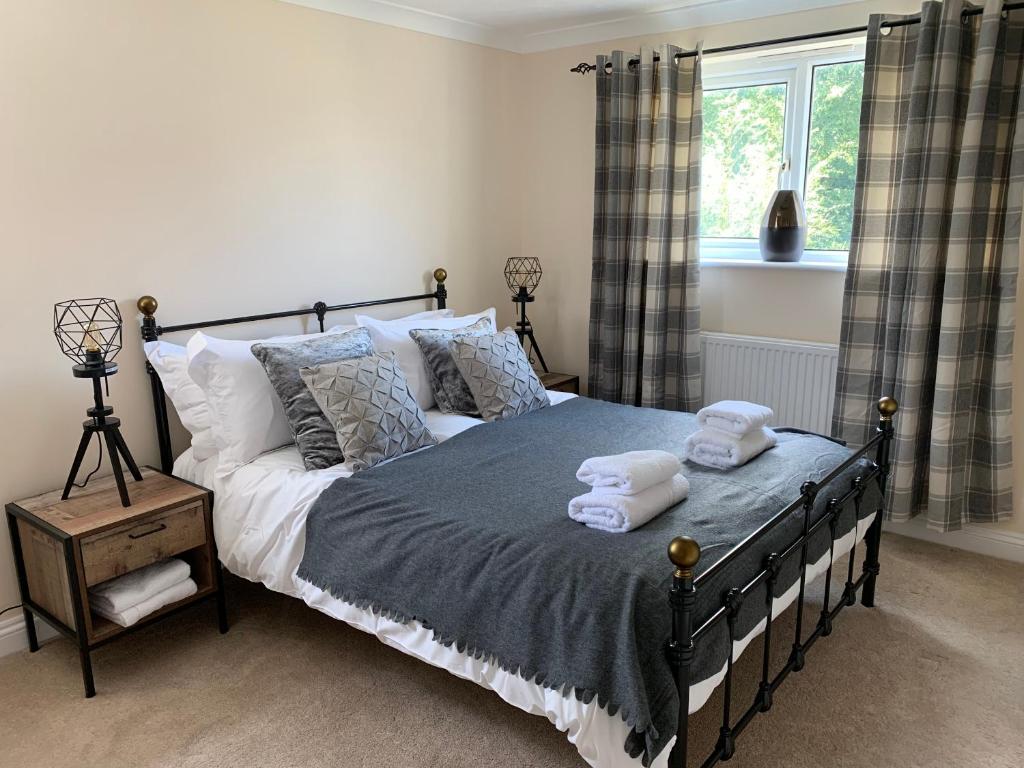 a bedroom with a bed with two towels on it at Thorn House a beautiful large house in Witney in Witney