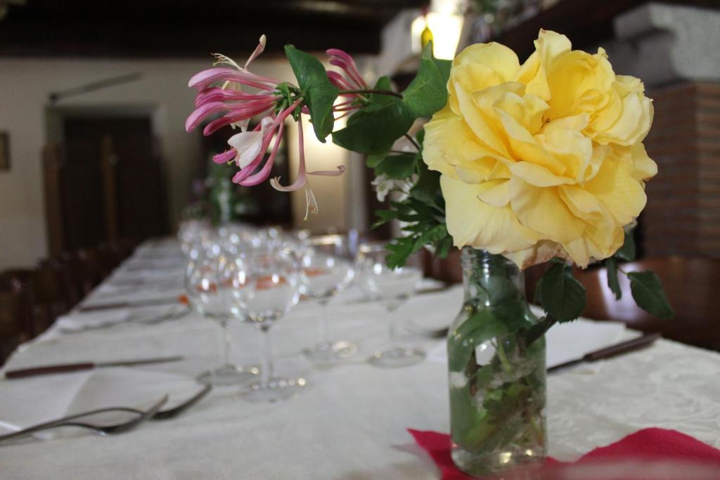 un tavolo con un vaso con fiori gialli di Biobagnolese Agriturismo a Orte
