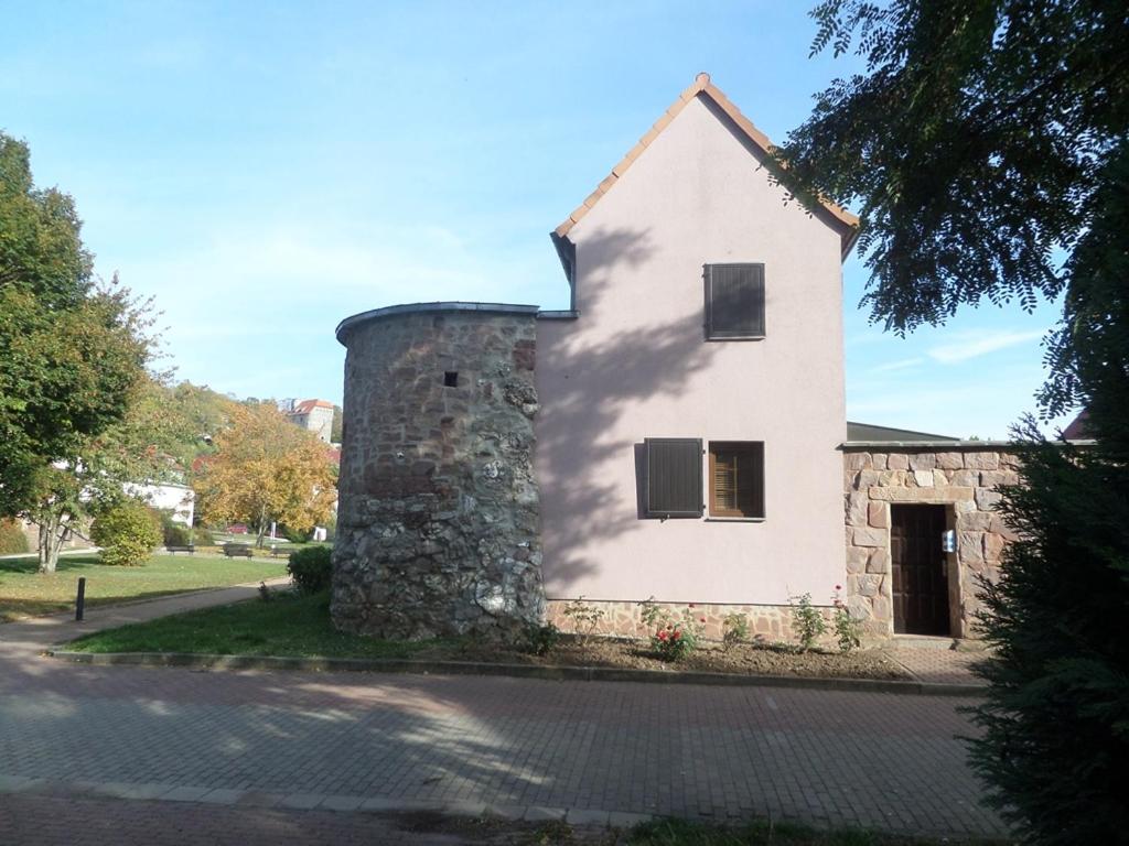 een wit huis met een stenen muur bij Ferienhaus Kyffhäuser in Bad Frankenhausen