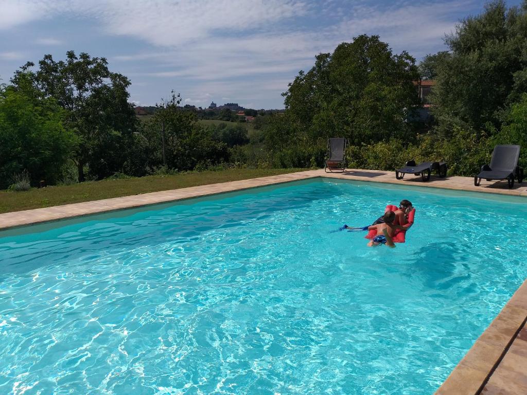 Zwei Personen sind in einem Pool mit blauem Wasser in der Unterkunft Fattoria Capobianco in Montefiascone