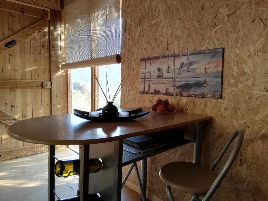 a table and chairs in a room with a window at Wooden House at the Mountain-private in Paránimfoi