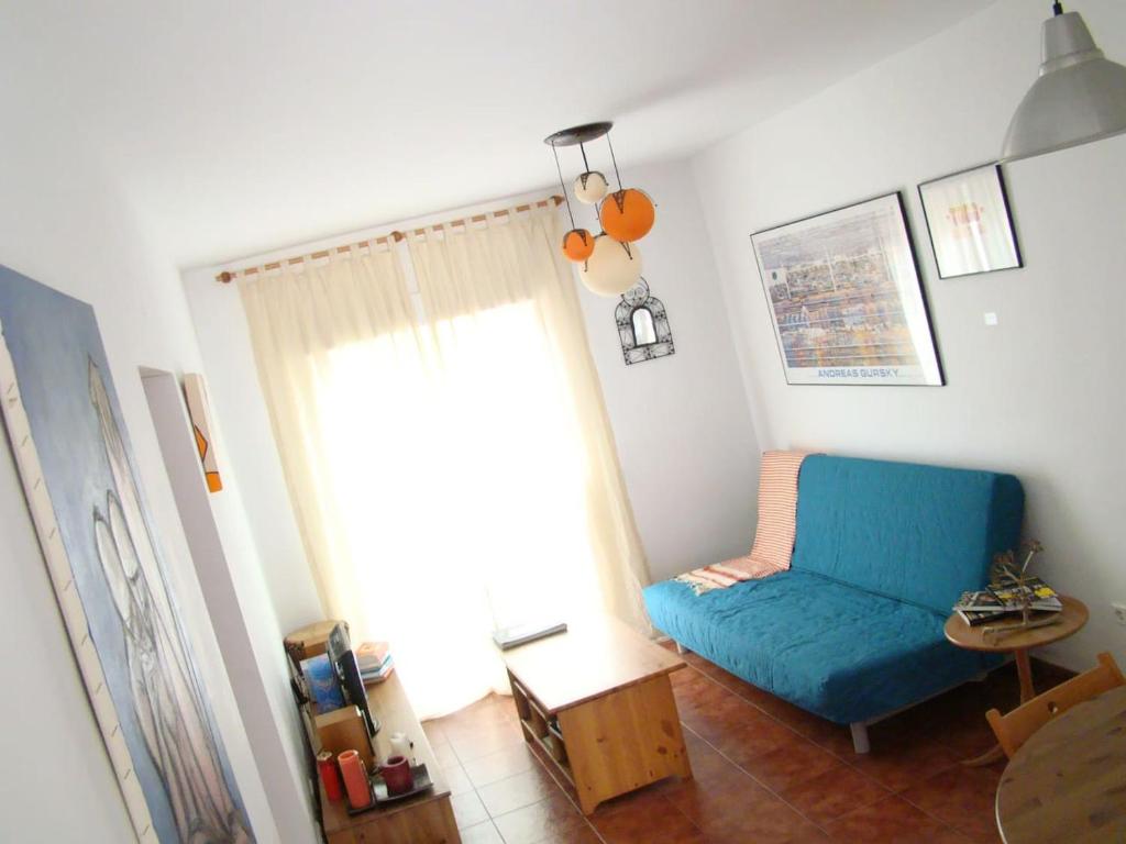 a living room with a blue chair and a window at Nuestra casita en CABO DE GATA in El Pozo de los Frailes