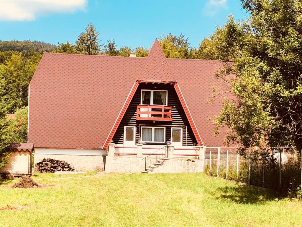 une maison avec un toit rouge et une cour dans l'établissement Casă de vacanță Cheia, à Cheia