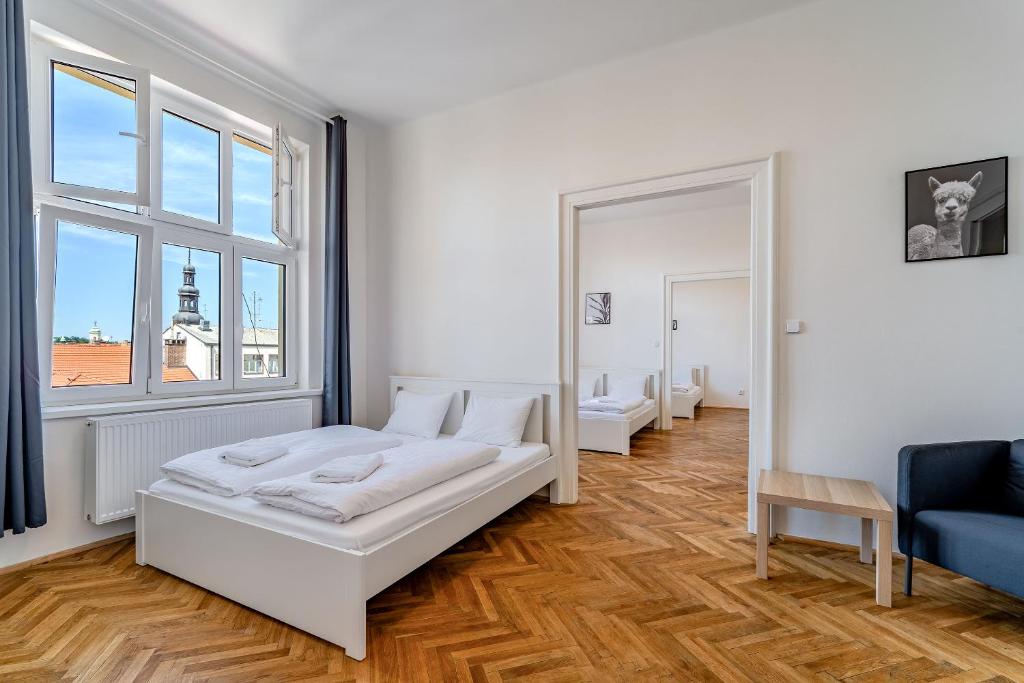 a white room with a bed and a mirror at Avantguard Apartments in Prague