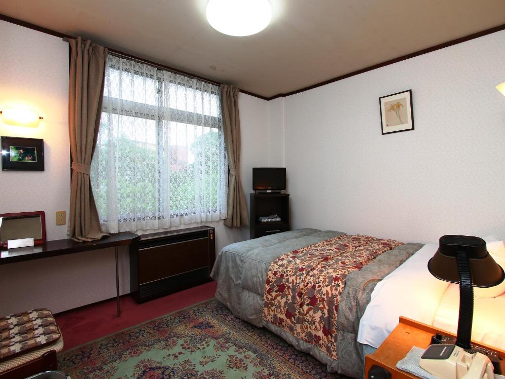Postel nebo postele na pokoji v ubytování Hotel Mumon