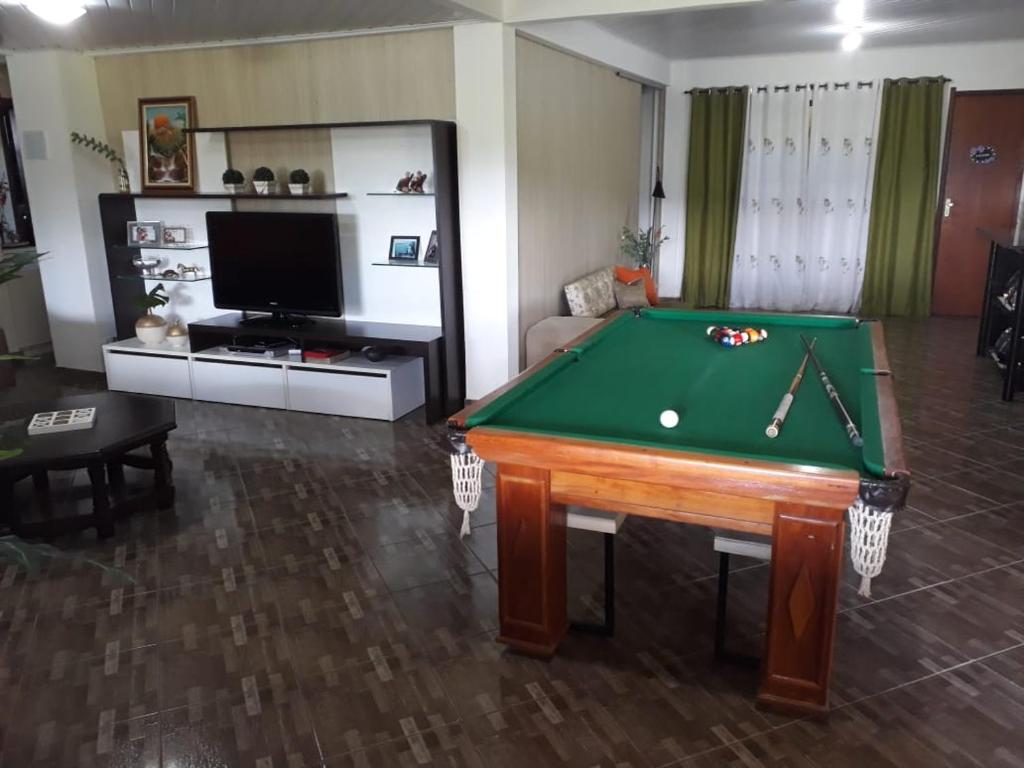 a living room with a pool table and a tv at Casa ampla com vista para as montanhas com piscina in Nova Friburgo