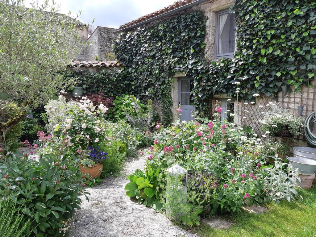 um jardim com flores em frente a uma casa em La Petite Maison em Laroque-Timbaut