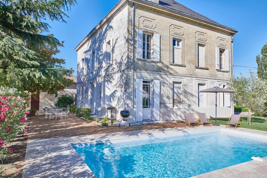 une maison avec une piscine devant une maison dans l'établissement Luxurious Wine Estate Saint-Emilion Grand Cru with private swimming pool, à Saint-Hippolyte