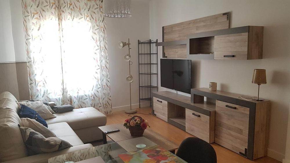 a living room with a couch and a flat screen tv at Apartamentos Puerta de Nájera in Nájera