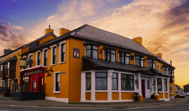 a large yellow building on a city street at Bay View Hotel in Kilkee