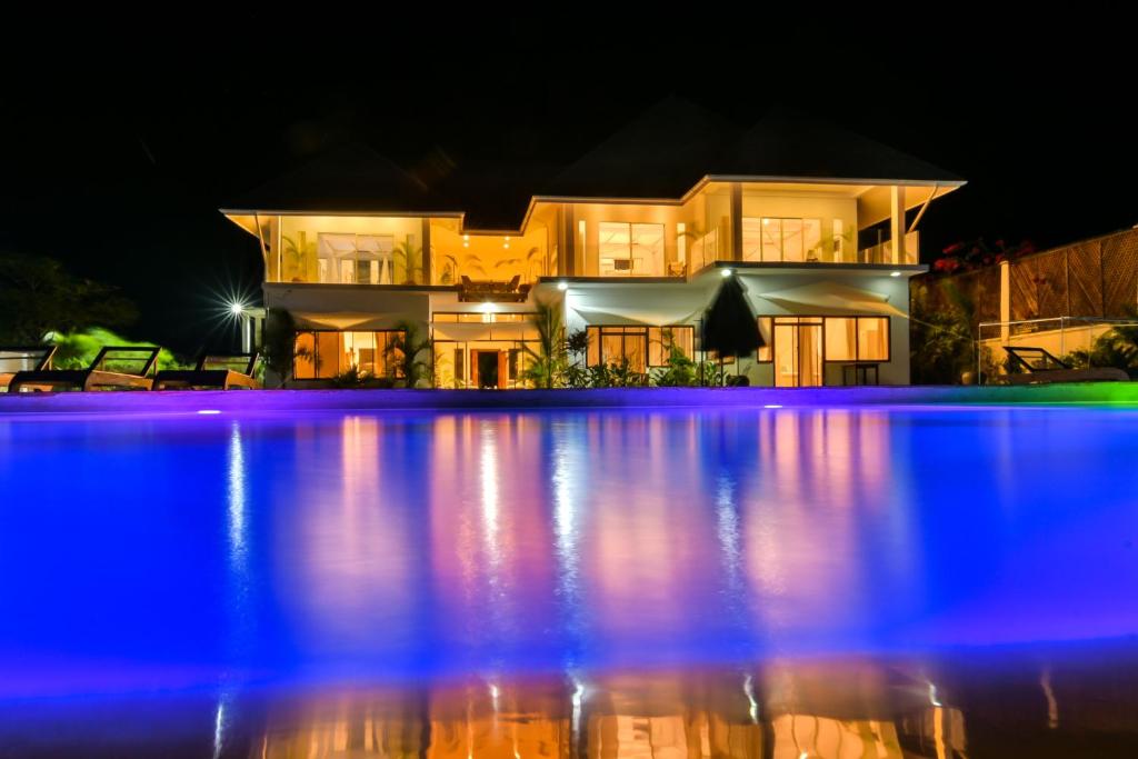 a house with a swimming pool at night at The Palm Residence by Amazing Zanzibar in Chanjani