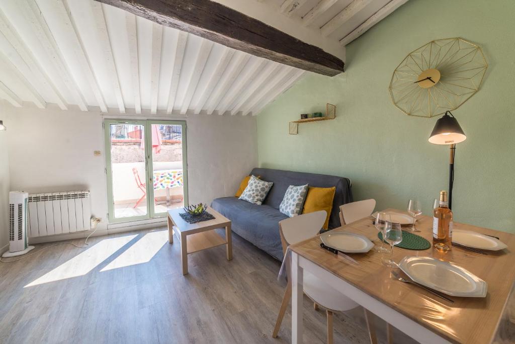 - un salon avec un canapé bleu et une table dans l'établissement Apt terrasse centre historique, à Grasse