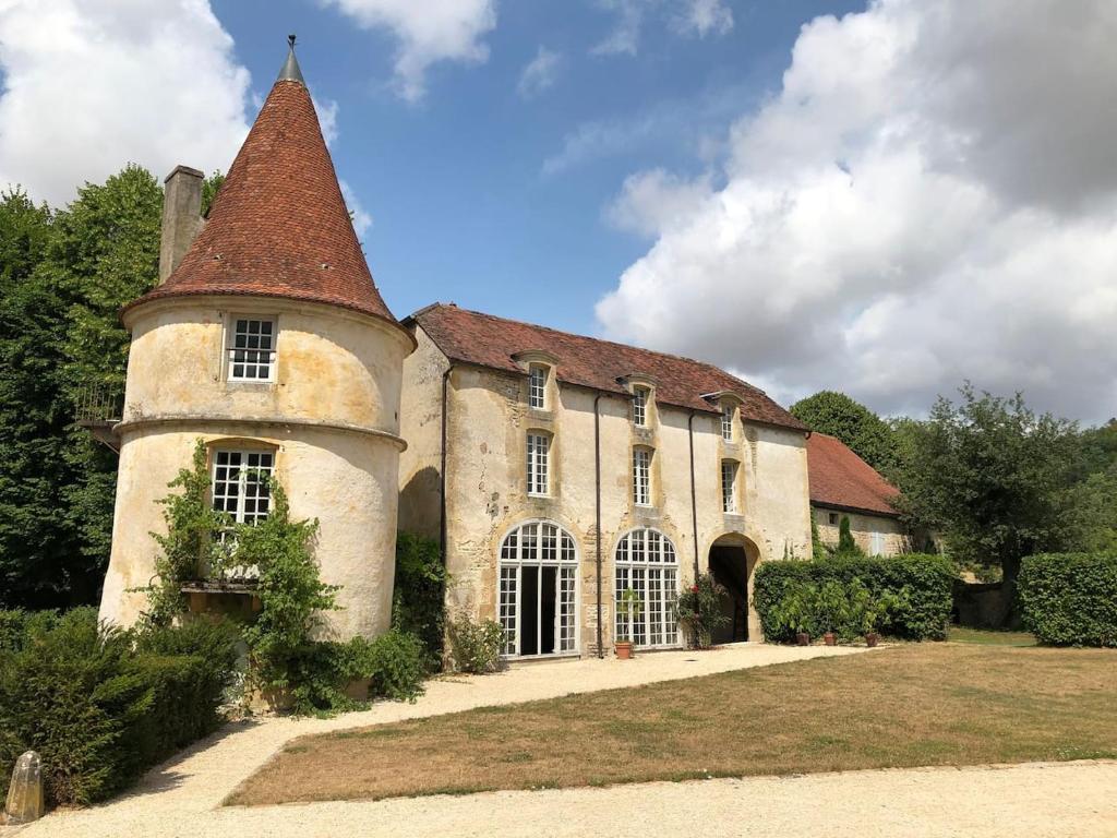 ein altes Gebäude mit einem Turm darüber in der Unterkunft Orangerie du chateau de Quemigny sur Seine in Quemigny-sur-Seine