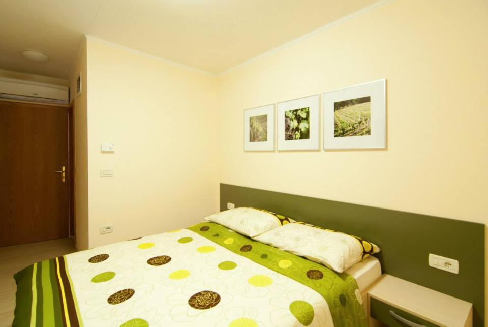 a bedroom with a bed with a green and yellow comforter at Kraljič - Primož Čotar in Dornberk