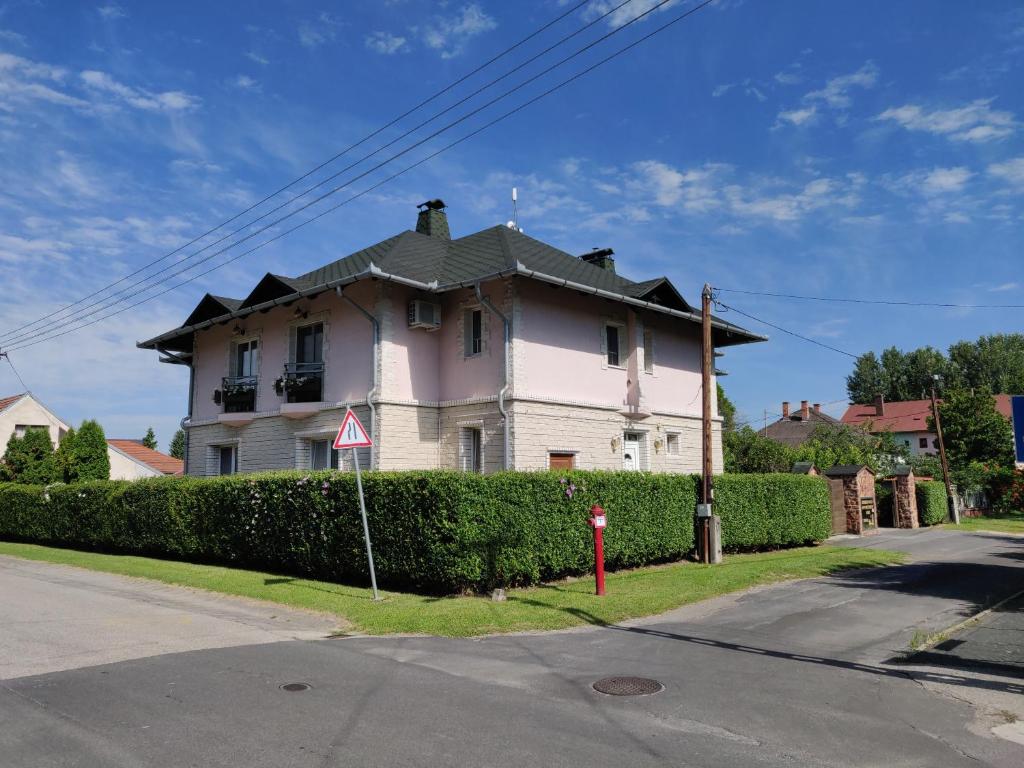 Biały dom z czarnym dachem na ulicy w obiekcie Vilma Villa w mieście Balatonmáriafürdő