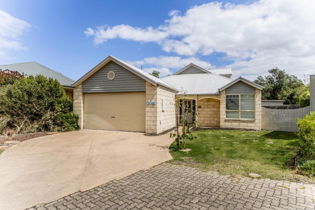 uma casa com garagem e uma entrada em WALKIN ON SUNSHINE - STROLL TO BEACH BREAK em Inverloch