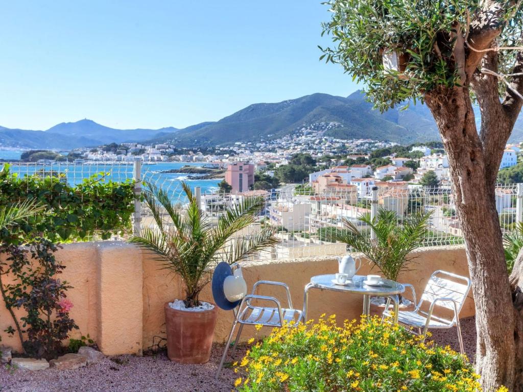 un patio con mesa y sillas y vistas a la ciudad en Apartment Rosa Maria by Interhome, en Llançà