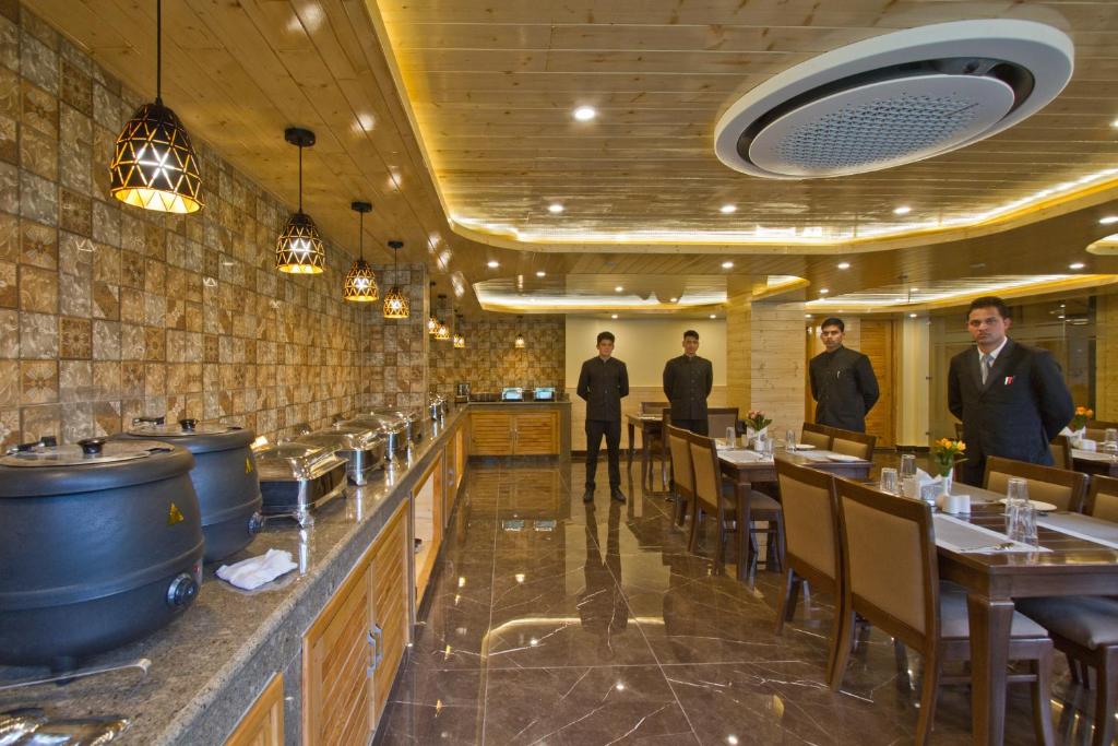 a restaurant with people standing in the dining room at The Holiday Villa Resorts & Spa in Manāli