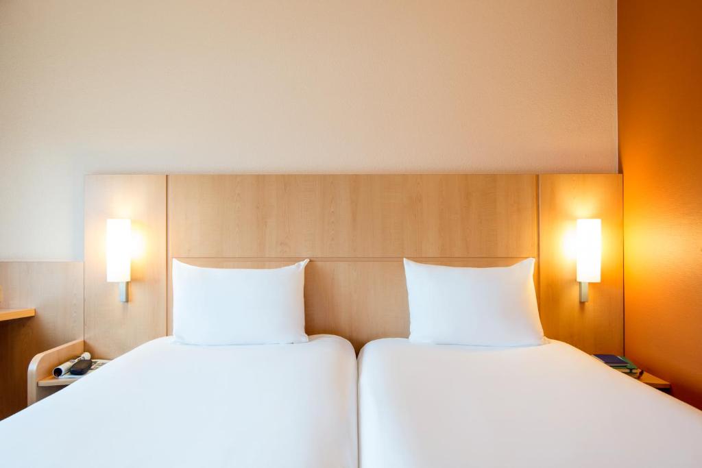 two beds sitting next to each other in a room at Ibis Schiphol Amsterdam Airport in Badhoevedorp