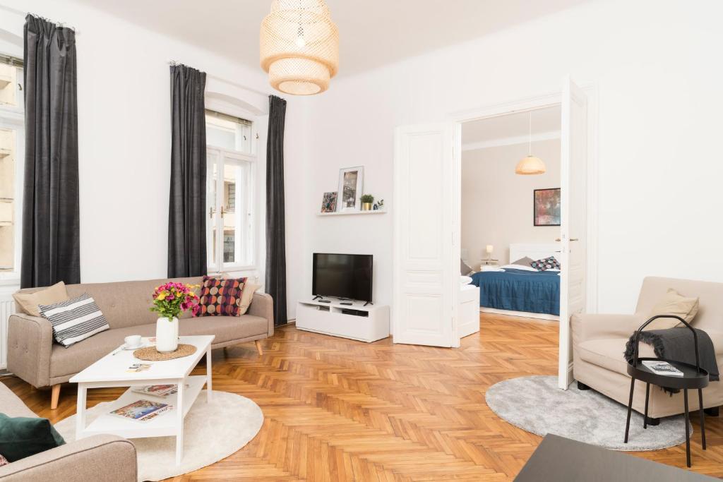 ein Wohnzimmer mit einem Sofa und einem TV in der Unterkunft Spittelau Chillout Lounge upto7P spacious bright contactless24h in Wien