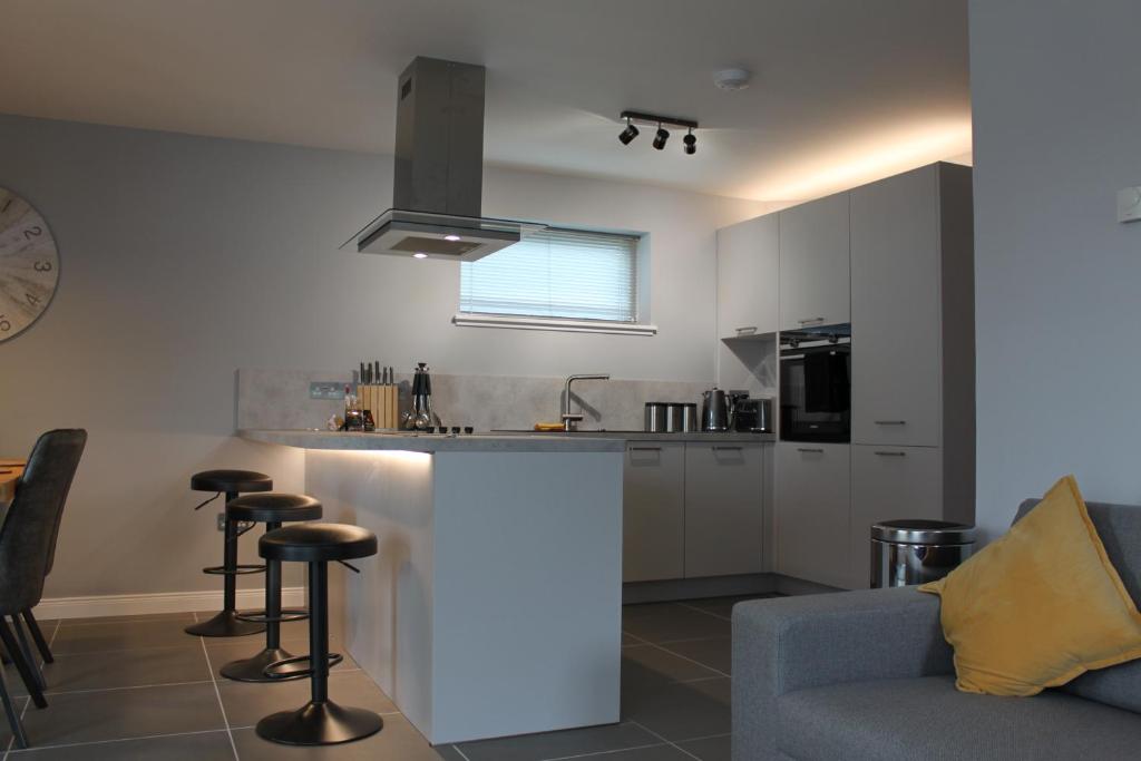 a kitchen with a counter and some chairs in a room at Apt 1, Frasers Close, Kirkwall in Kirkwall