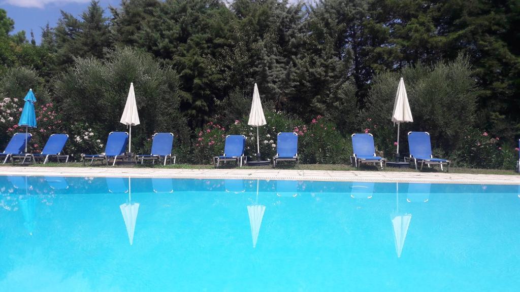 un grupo de sillas y sombrillas y una piscina en Lemontree Apartments, en Kassiopi