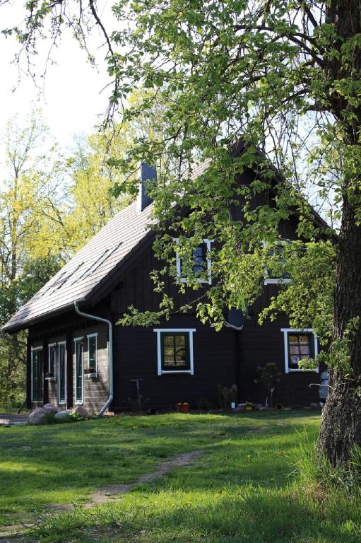 a black house with a tree in front of it at Der Kolonist in Burg