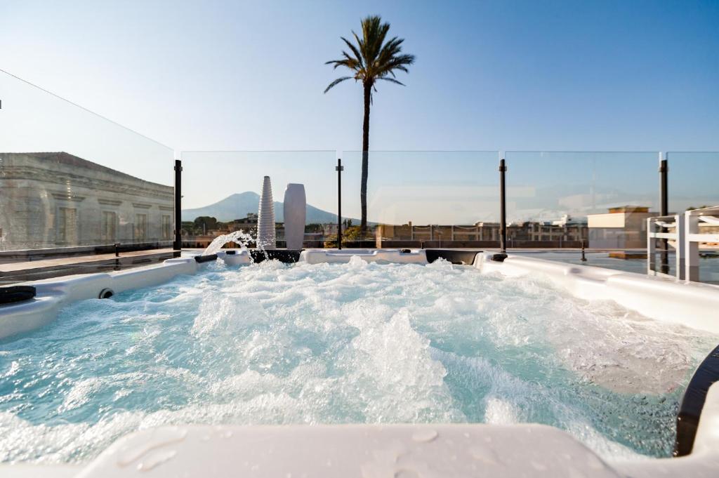una vasca idromassaggio con acqua e una palma di Dream House Pompei a Pompei
