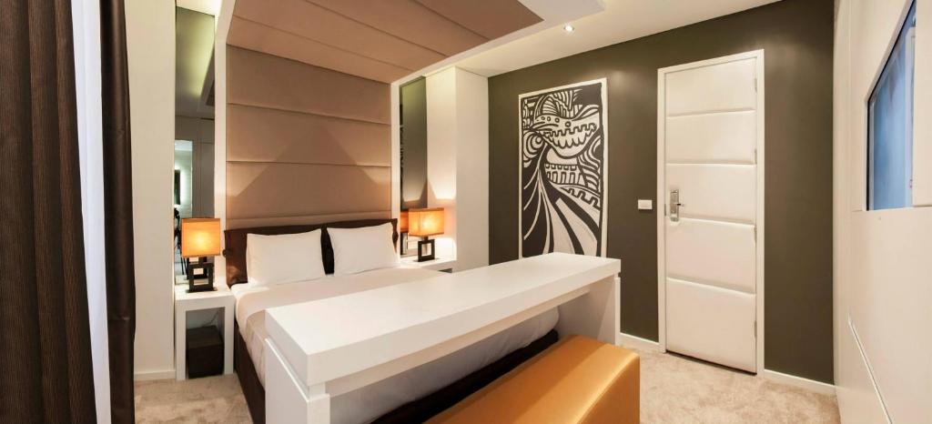 a bedroom with a white bed and a painting on the wall at Eden Garden Suites in Belgrade