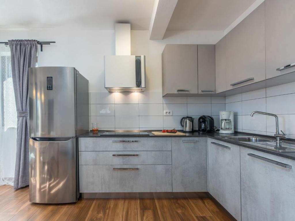 kuchnia z lodówką ze stali nierdzewnej i drewnianymi podłogami w obiekcie Holiday Home Villa Joy by Interhome w mieście Novigrad
