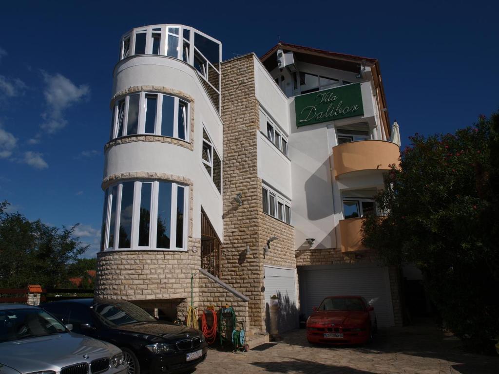 un bâtiment avec un panneau sur son côté dans l'établissement Apartments and bungalows vila Dalibor, à Nin
