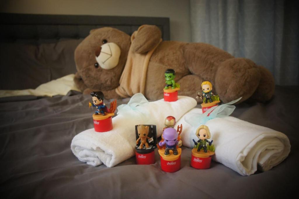 a group of toy figurines sitting on a towel with a teddy bear at Malaysia Johor Medini Studio in Nusajaya