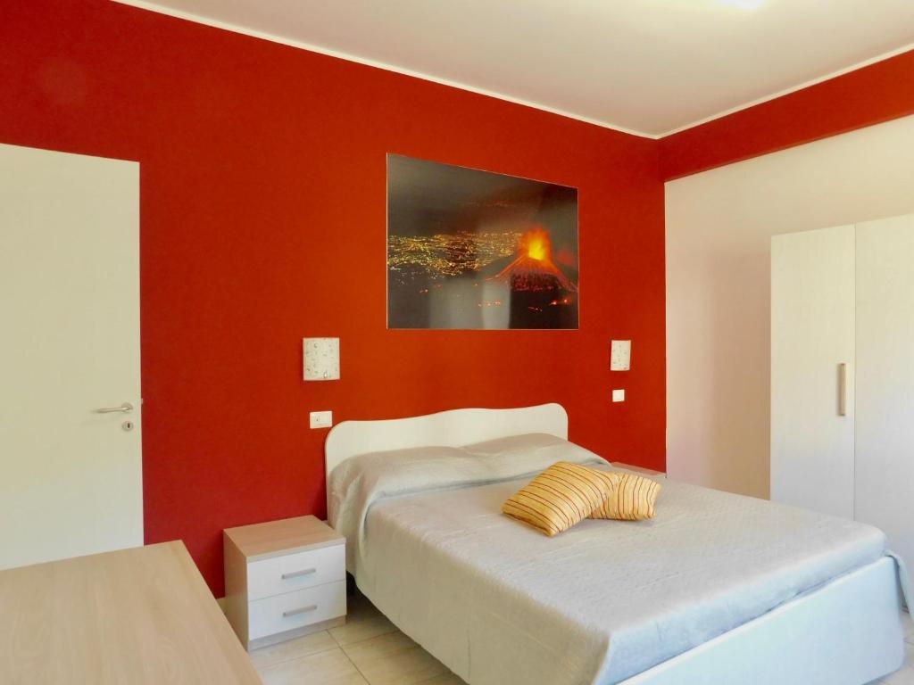 1 dormitorio con paredes rojas y 1 cama. en Vanilla Apartments, en Giardini Naxos