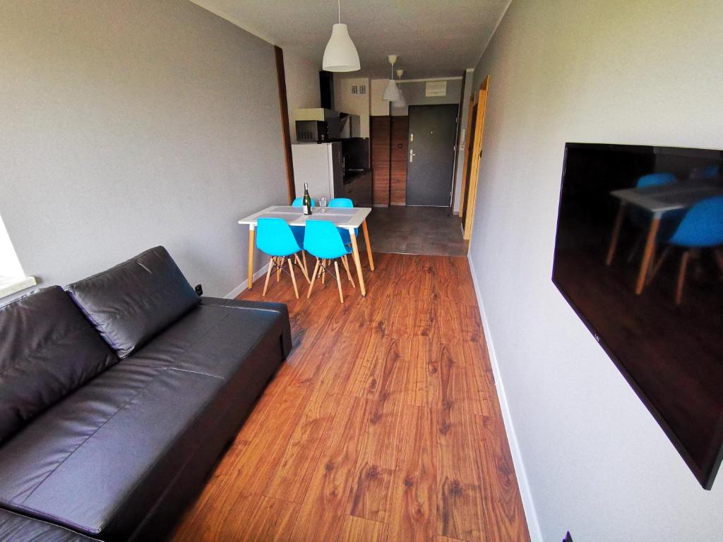 a living room with a couch and a table and chairs at Apartment Cyprys 1 in Oświęcim