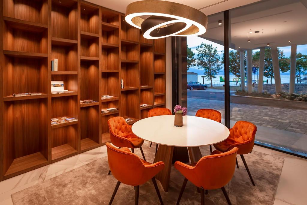a dining room with a table and orange chairs at Luxury Hotel Riva in Malinska
