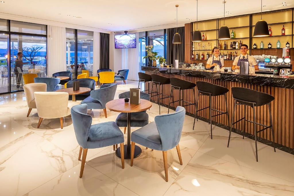 a restaurant with tables and chairs and a bar at Luxury Hotel Riva in Malinska