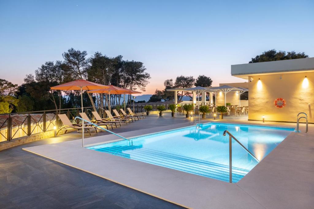 uma piscina num hotel com cadeiras e guarda-sóis em Hotel Admiral Casino & Lodge em San Roque