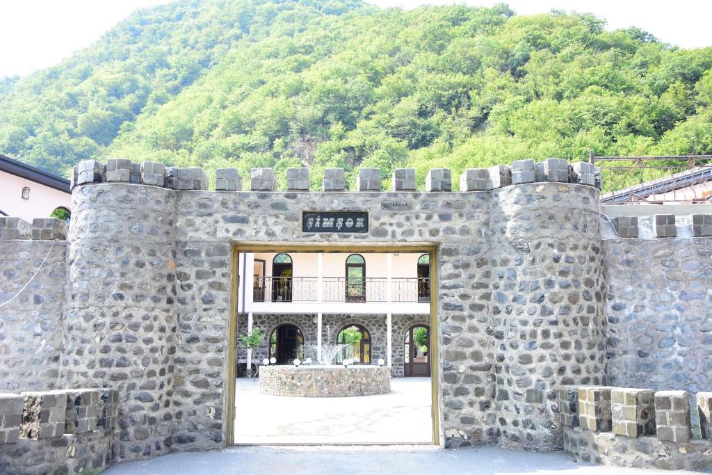 una puerta en una pared de piedra con una montaña en el fondo en SİMSEK HOTEL&Restourant, en Qax