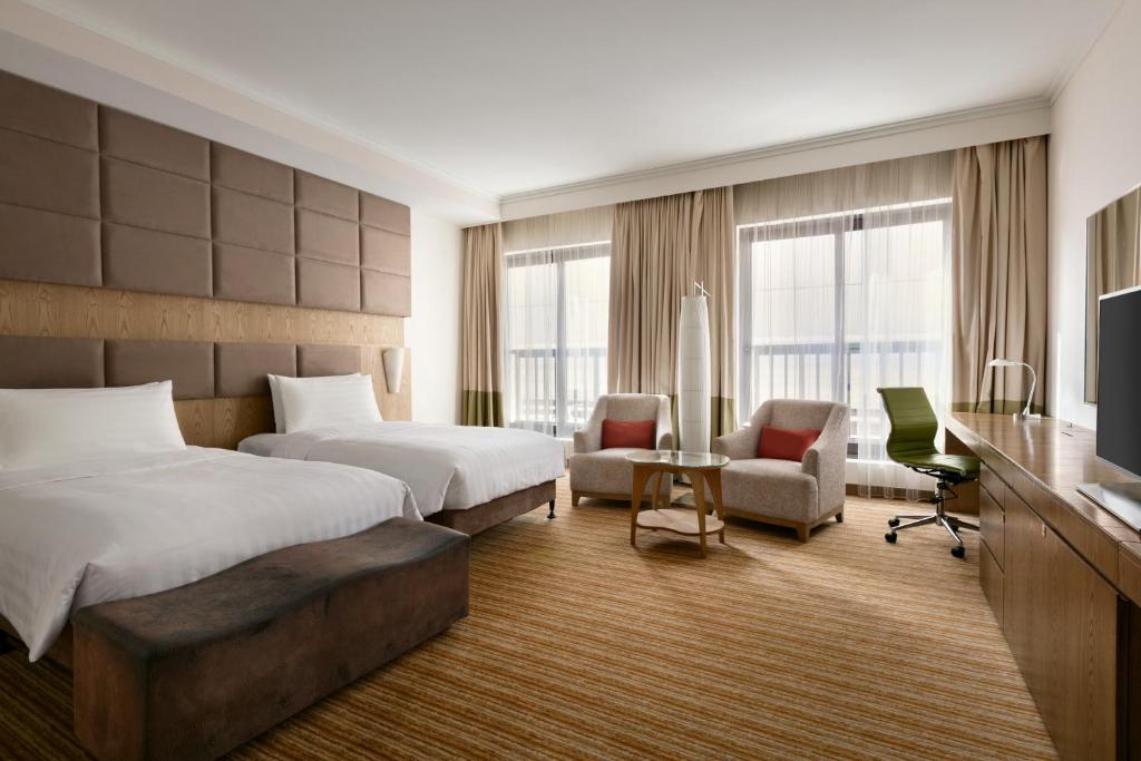 a hotel room with two beds and a television at Traders Hotel, Abu Dhabi in Abu Dhabi