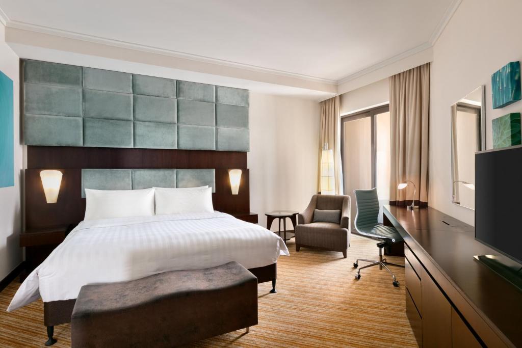 a hotel room with a bed and a desk at Traders Hotel, Abu Dhabi in Abu Dhabi