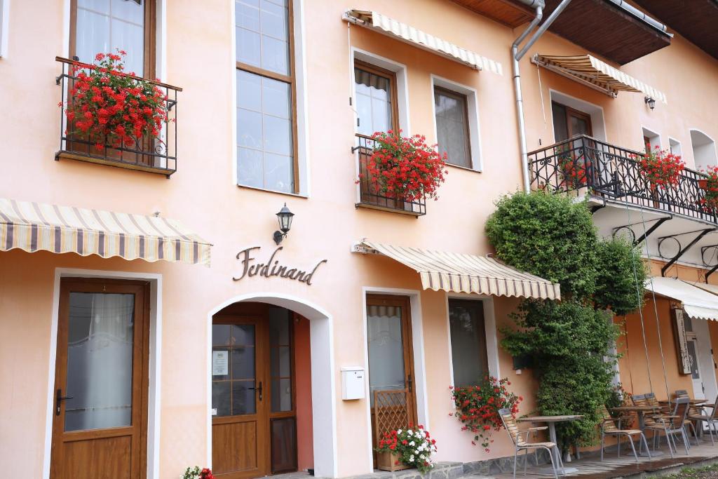 um edifício com flores nas varandas e janelas em Pension Ferdinand Panzio em Sfântu Gheorghe