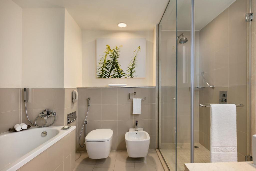 a bathroom with a toilet and a shower and a sink at Traders Hotel, Abu Dhabi in Abu Dhabi