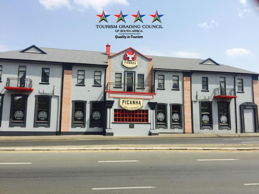 a building on the side of a street with a restaurant at Picanha Grill Guest House & Events Venue in Nigel