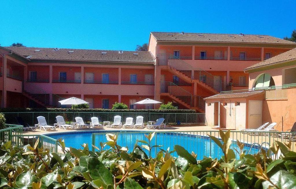 LinguizzettaにあるLes jardins de la mer marine de bravone - 2 chambres à lit plus sofa avec piscine à coté merの建物の前にスイミングプールがあるホテル
