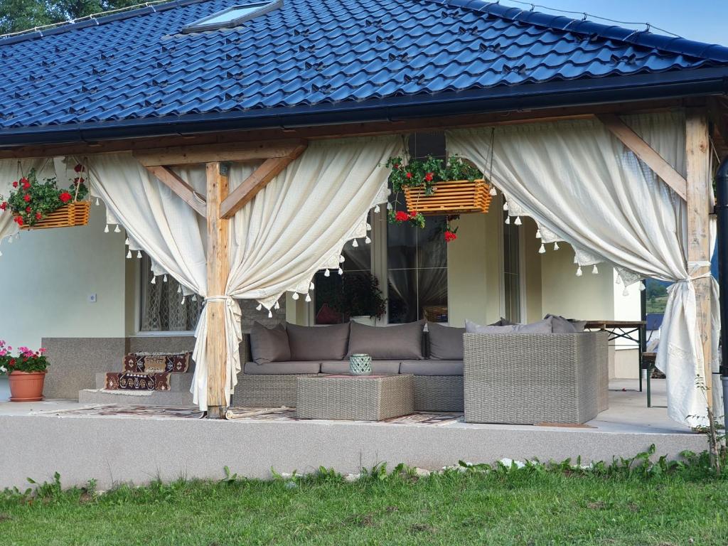 un pavillon avec un canapé sous un toit bleu dans l'établissement Planinski RaJ - Mountain PaRaDiSe, à Trnovo