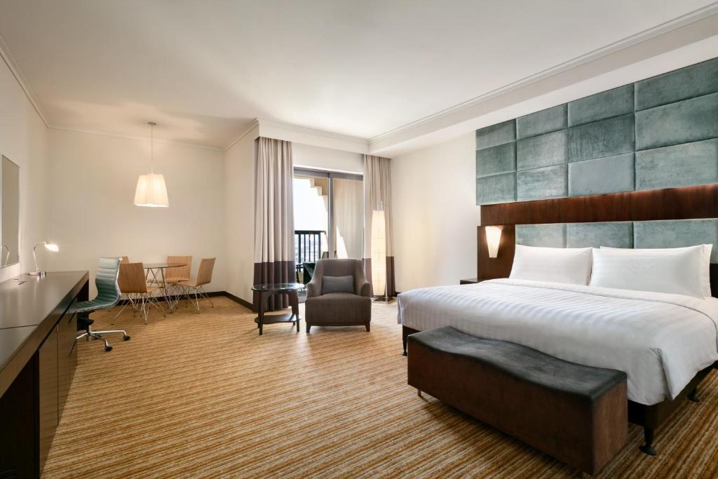 a hotel room with a bed and a desk at Traders Hotel, Abu Dhabi in Abu Dhabi