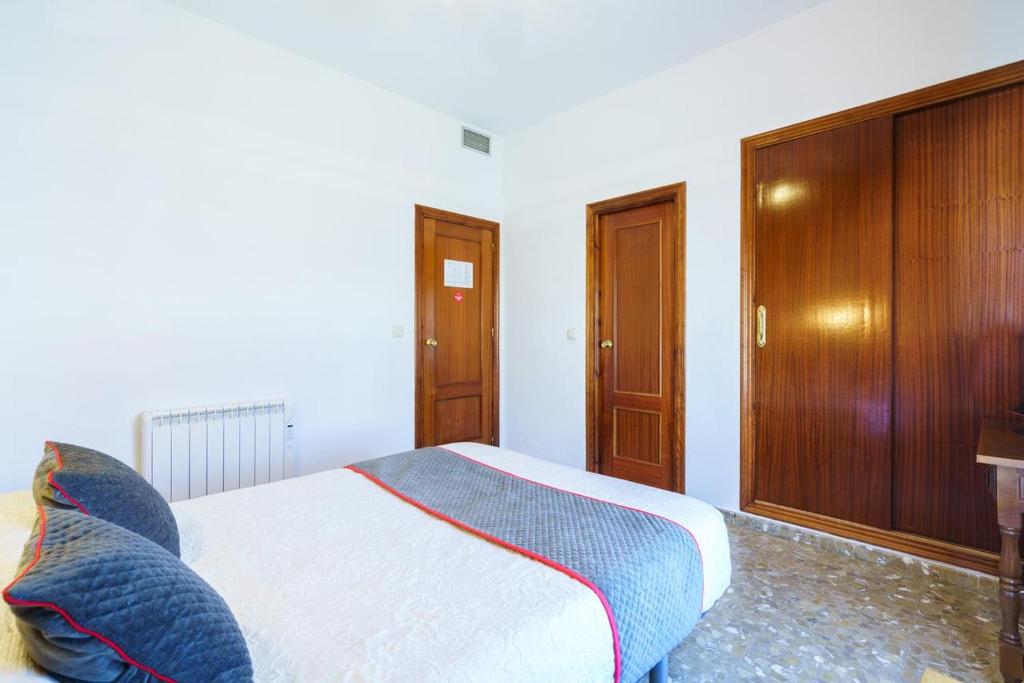 una camera con letto e armadio in legno di HOTEL RESTAURANTE MOYA a Monesterio